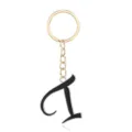 Close-up of a stylish gold metal keychain with a chic black letter pendant detail. - Letter I