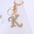 Close-up detail shot of a sparkling rhinestone letter K keychain pendant with a gold finish. - Letter K