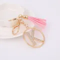 Detailed close-up view of the gold rhinestone letter K keychain with pink leather tassel. - Letter K