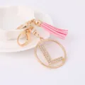 Detailed view of the rhinestone letter L keychain with pink tassel, metal ring and clasp accessory. - Letter L