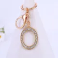 Gold rhinestone letter O keychain pendant detail, sparkling crystal alphabet keyring accessory. - Letter O
