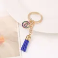 Vue détaillée d'un porte-clés doré élégant avec gland bleu et charm en strass lettre B brillante. - Lettre B