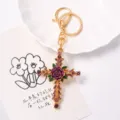 Detailed view of vintage rhinestone rose cross keychain, gold metal finish with purple enamel. - Purple