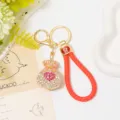 Detailed close-up of rhinestone heart money bag keychain with red leather braided strap. - Color 3 with Leather Strap