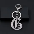 Detailed view of silver rhinestone letter keychain with lobster clasp, luxury accessory. - Letter G