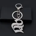 Silver rhinestone gothic letter keychain detail showing sparkling crystal metallic pendant hardware. - S