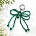 Detailed close-up view of the sparkling green crystal bow keychain and elegant bag charm. - Green