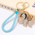 Gros plan détaillé du porte-clés éléphant couronne strass luxueux avec lanière tressée bleue. - Couleur 2