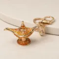 Gros plan détaillé d'un porte-clés en métal doré en forme de lampe magique d'Aladdin sculpté. - Or