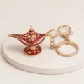 Vue détaillée du porte-clés lampe magique rétro, pendentif de sac en alliage rouge et or. - Or rouge