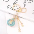 Detailed view of rhinestone dollar bag keychain, sparkling crystal metal pendant accessory. - Lake Blue