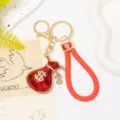 Porte-clés bourse rouge avec lanière en cuir tressé et pendentif dollar en métal strassé chic. - Couleur 3 avec Lanière en Cuir