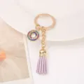 Chic rhinestone circle keychain with purple leather tassel, elegant gold metal key ring. - Letter O