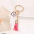Gold-tone keychain with colorful rhinestone round charm and pink tassel for bags and keys. - Letter V