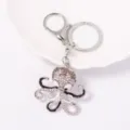 Primo piano dettagliato di un portachiavi a polpo con strass lucidi e struttura in metallo. - Argento