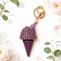 Close-up detail of the purple rhinestone ice cream keychain with gold clasp and flower decor. - Purple
