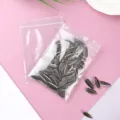Close-up of transparent PE zip lock bag filled with sunflower seeds for storage - Pack of 200 (7x10cm, 16 Silk) / White Edge Pink