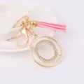 Detailed view of gold metal rhinestone letter O keychain with chic pink leather tassel charm. - Letter O