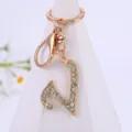 Close-up of a sparkling rhinestone alphabet letter keychain pendant in gold alloy finish. - Letter V