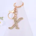 Close-up detail of the gold rhinestone letter K keychain pendant with lobster clasp and ring. - Letter X