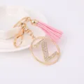 Close-up detail view of the gold rhinestone letter Z keychain featuring a pink tassel pendant. - Letter Z