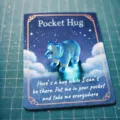 A small blue crystal pocket hug bear figurine placed on a starry sentimental greeting card - Polar Bear