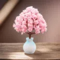 Vista detallada del árbol de flores de cerezo artificial en un jarrón azul para decoración. - Botella Azul Árbol del Amor