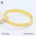 Vue de détail en gros plan du bracelet jonc en acier inoxydable doré avec des cristaux étincelants. - Style 11