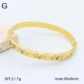 Gros plan détail du bracelet jonc ouvert en acier inoxydable doré avec strass 60x6mm. - Style 12