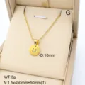 Gros plan détaillé du pendentif minimaliste en acier inoxydable doré lettre U dans son écrin. - Lettre U / Or 18 carats