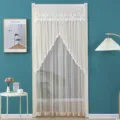 Detailed view of the white lace door curtain with delicate embroidery and pom-pom trim in room. - 100 x 200 cm with Hook & Loop Fastener / Abundant Blessings Beige