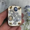 Detailansicht der handgefertigten Mini-Blumenpresse aus Metall mit Edelsteinverzierung - Vergissmeinnicht / 10 Blatt Papier Inklusive