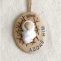 Nahaufnahme des rustikalen Baby Jesus Ornaments mit graviertem Text und Hanfseil - Weihnachts-Baby-Hängeanhänger