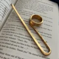 Segnalibro ad anello in metallo dorato martellato su pagine di un libro aperto. - Pezzo Singolo / Oro