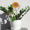 Nahaufnahme eines kreativen orangefarbenen Blumensteckers mit Augendesign im Topf. - Blumenaugen-Stil / 1 Stück