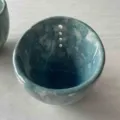 Artisan teal glazed pottery herb stripper bowl featuring functional leaf removal holes - Blue Glaze
