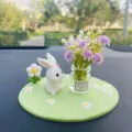Gros plan détaillé d'un joli ornement de lapin blanc en résine avec mini vase pour voiture. - Lapin Bouquet + Vase Gypsophile Violet + Tapis Vert