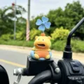 Close-up detail of cute yellow capybara toy with blue windmill decoration mounted on motorcycle. - Sofa Shocked (Adhesive Type)