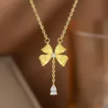 Makroansicht einer vergoldeten Schleifenhalskette mit funkelndem Tropfen-Zirkon-Anhänger - Schleife Wassertropfen Quaste Halskette (9137) / Gold