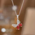 Makroaufnahme einer silbernen Schmetterlingshalskette mit roten Edelsteinen und klaren Kristallen - Roter Strass Schmetterling (Silber)