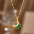 Detailansicht eines eleganten goldenen Schmetterlingsanhängers mit grünen Kristallen. - Grüner Strass Schmetterling (Gold)