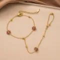 Detailansicht eines goldenen Titanstahl-Handkettchens mit lila Blumenperlen. - Fuchsie Blume Handkette (Gold)