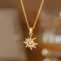 Detailaufnahme einer goldener Sonnenanhänger-Halskette mit funkelnden Kristallsteinen - Sonne (8392) / Gold