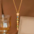 Primer plano detallado de collar dorado con colgante de estrella y circonitas de varios colores - Estilo Pentagrama Circonia de Colores (9491) / Dorado