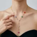 Detailansicht einer goldenen Y-Halskette mit bunten Perlenblumenanhängern am Modell - Bunte Perlenblumenquasten-Stil (H1131)