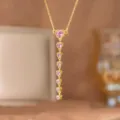 Close-up of elegant gold necklace featuring a vertical drop of pink heart-shaped zircons. - Heart Pink Zirconia Long Style (9494)