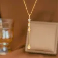 Detailed macro shot of a gold-toned necklace with star and geometric CZ pendant - Geometric Tassel Long Style (9495)