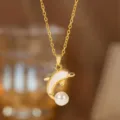 Detaillierte Makroaufnahme eines vergoldeten Delfin-Anhängers mit Muschel und Perle - Perlen-Weiße Muschel-Delfin-Halskette (8131) / Gold