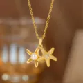 Detailansicht der eleganten, vergoldeten Doppelseestern-Halskette mit Perlen und Zirkon - Perlen-Seestern-Halskette (8132) / Gold