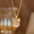 Nahaufnahme einer goldenen Schleifenkette mit Zirkonia und einer lavendelfarbenen Perle - Perlen-Schleifen-Halskette (8170) / Gold